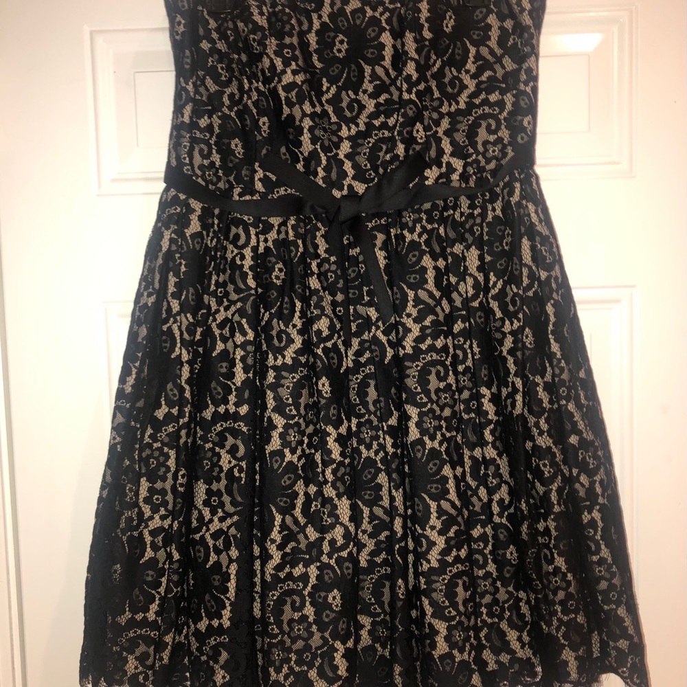 A tan fabric  dress with black lacing all over